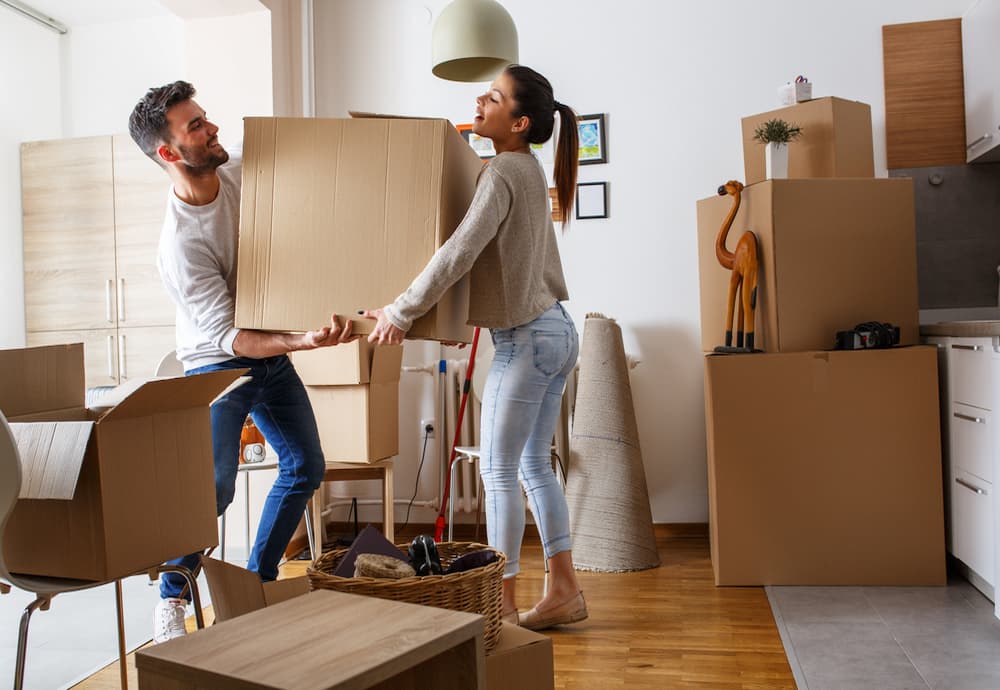 A couple moves their belongings out of their old apartment and into their new home